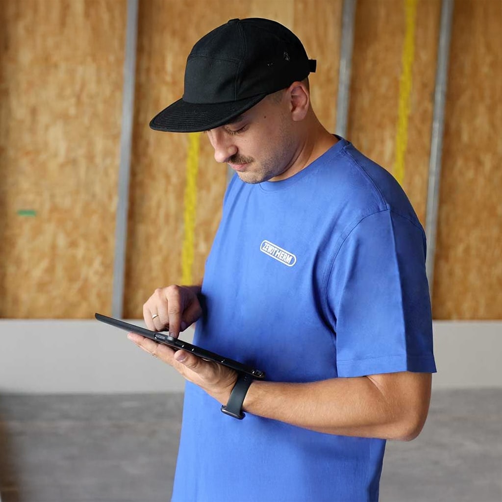 ZEWOTHERM Servicemitarbeiter bei der digitalen Anlagenprüfung über Tablet – technischer Kundendienst für Wärmepumpen
